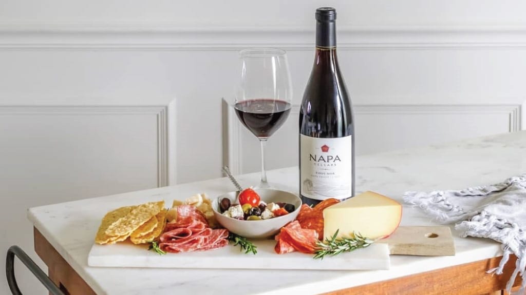 Californian red wine: a bottle of Napa Cellars pinot noir and half full glass with a charcuterie platter