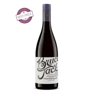 A bold bottle of Bruce Jack Pinotage Malbec set against a rustic wooden table, with rich garnet tones in a wine glass—capturing the essence of South African craftsmanship.